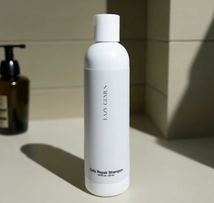 Daily Repair Shampoo surrounded by natural ingredients like aloe vera, pomegranate, and olive oil.